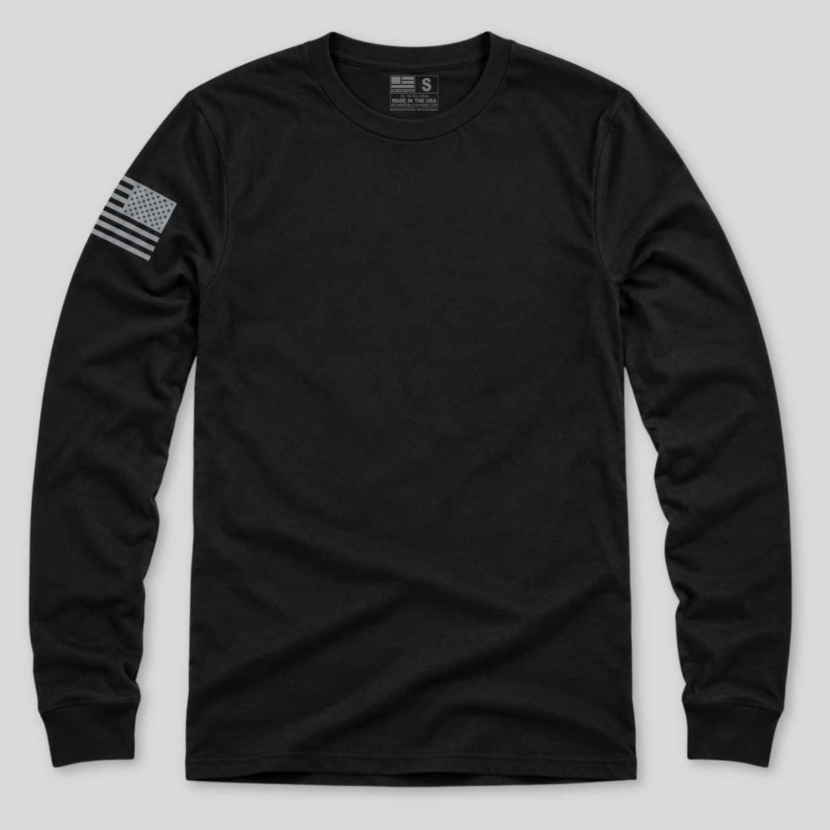A black long-sleeve crewneck t-shirt with a distressed gray American flag graphic on the left sleeve, displayed against a light gray background.