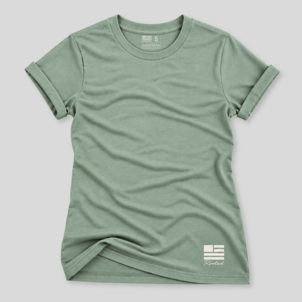 A sage green short-sleeve crewneck t-shirt with a small white logo on the bottom right, displayed flat against a light gray background.