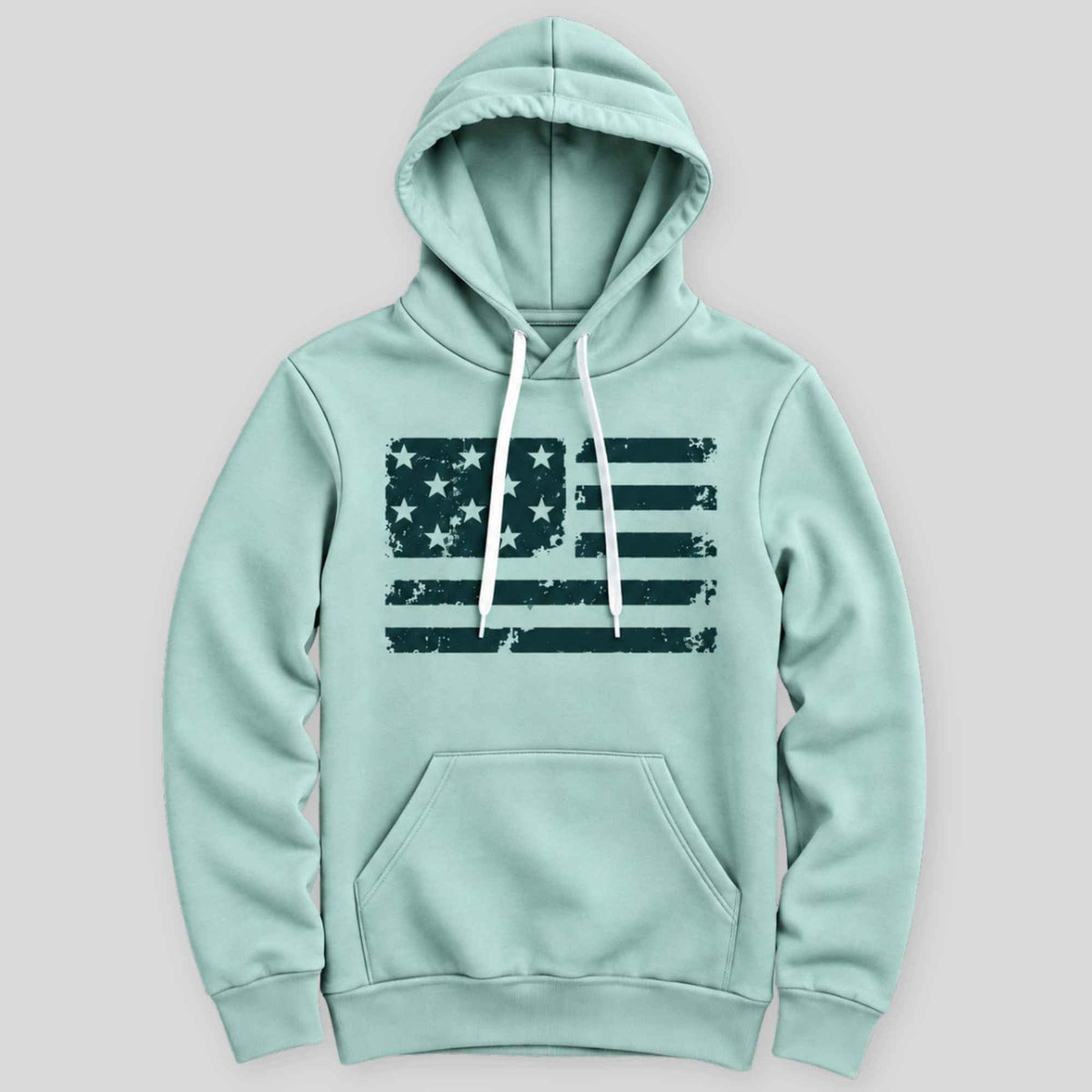 A mint green pullover hoodie with a distressed dark green American flag graphic on the chest, featuring white drawstrings and a front kangaroo pocket, shown against a solid gray background.