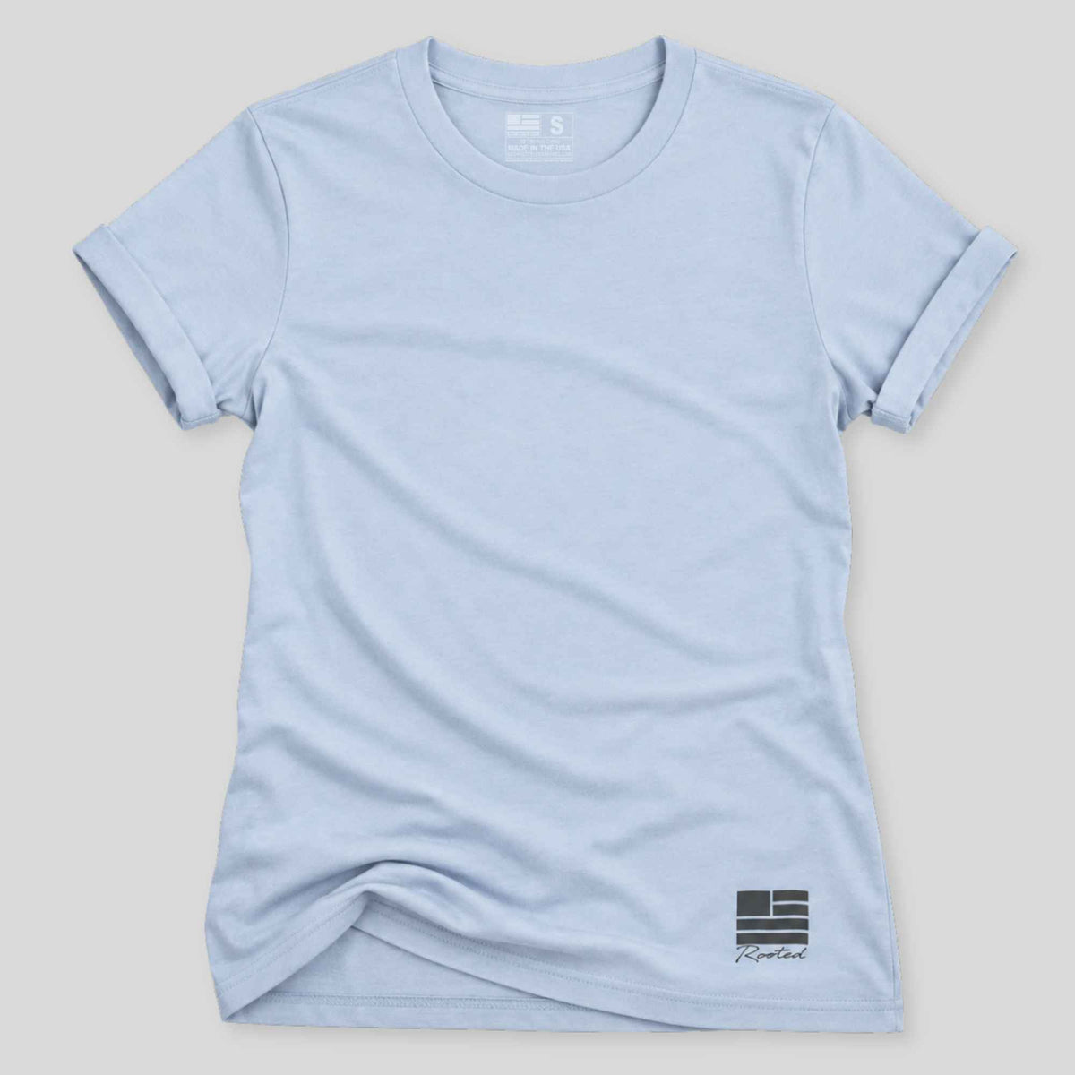A light blue short-sleeve crewneck t-shirt with a small black and white graphic on the bottom right, displayed flat against a neutral light gray background.