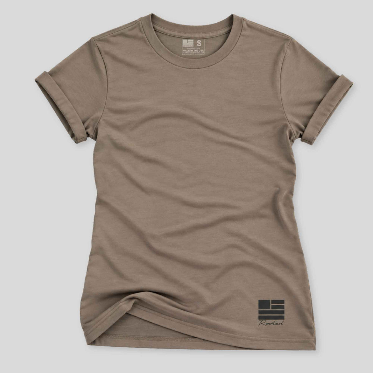 A short-sleeve crewneck t-shirt in a muted taupe-brown color, featuring a small black graphic logo on the bottom right hem. The shirt is laid flat against a light gray background.