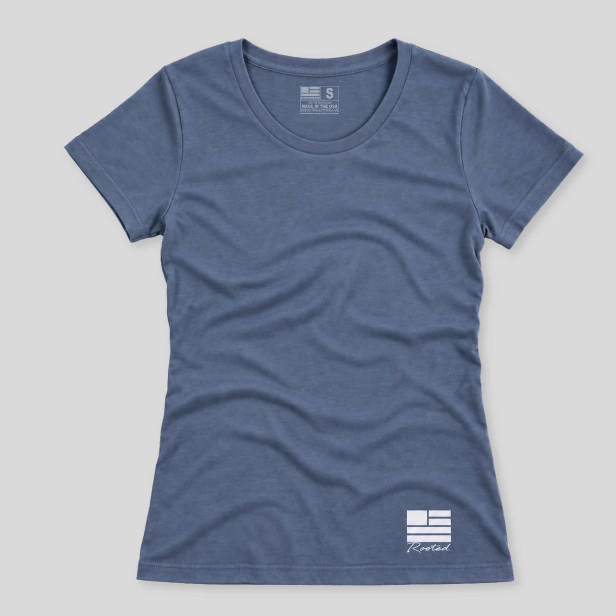 A women's short-sleeve crewneck t-shirt in heathered slate blue, featuring a small white graphic logo on the bottom right hem and a size/brand label inside the collar, shown flat against a light gray background.