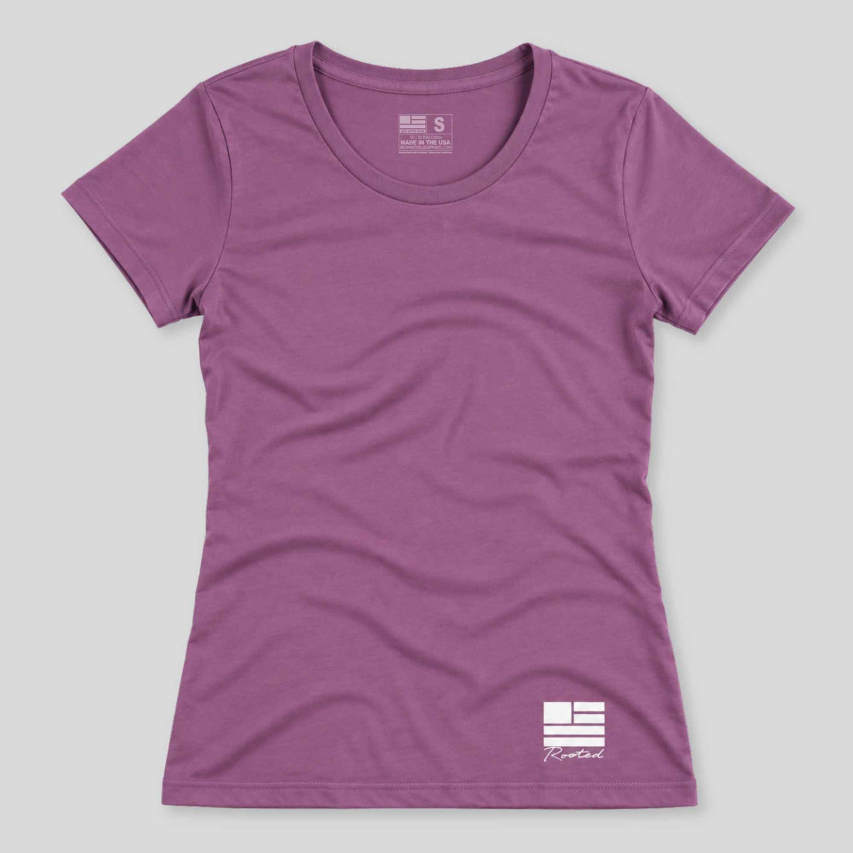 A women's short-sleeve crewneck t-shirt in a heathered purple color, featuring a white graphic logo on the bottom right and a size tag on the inner neck label, displayed against a neutral gray background.