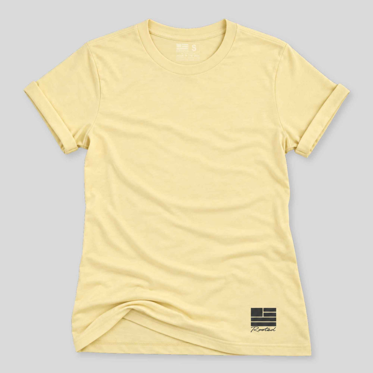 A pale yellow short-sleeve crewneck t-shirt with a small black graphic logo on the bottom right, displayed flat against a light gray background.